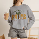 Fort Myers Palms Crewneck Sweatshirt in sport grey with the palm tree between bold gold block letters with a baseball on the front, worn by model