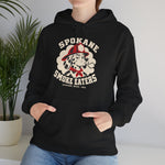 Spokane Smoke Eaters Hoodie in black with the Spokane Smoke Eaters logo, a Dalmatian in a red fire helmet and bandana blowing smoke on the front, worn by model