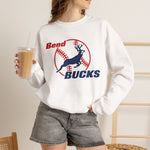 Bend Bucks Crewneck Sweatshirt in white with the Bend Bucks logo, a leaping buck over a red-stitched baseball on the front, worn by model