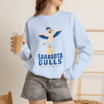 Sarasota Gulls Crewneck Sweatshirt in light blue with the cream cartoon gull balancing on a baseball with wings spread on the front, worn by model