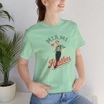 Miami Hustlers Premium Lightweight T-Shirt in mint with the mustached man in a striped vest holding playing cards and a bat on the front, worn by model