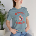 Key West Conchs Premium Lightweight T-Shirt in heather blue lagoon with the grinning striped conch shell mascot inside a teal diamond outline on the front, worn by model