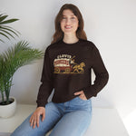 Clovis Pioneers Crewneck Sweatshirt in dark chocolate with the Clovis Pioneers logo, a ballplayer with a raised bat riding a horse-drawn covered wagon, with Pioneers on the canvas on the front, worn by model