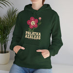 Palatka Azaleas Hoodie in forest green with the smiling pink flower mascot with two baseballs above it on the front, worn by model