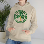 Roseburg Shamrocks Hoodie in sand with the Roseburg Shamrocks logo, a shamrock of baseballs with a bat stem in a green ring on the front, worn by model