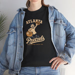 Atlanta Pretzels Heavyweight T-Shirt in black with the cream cartoon baker holding a pretzel and basket on the front, worn by model