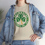 Roseburg Shamrocks Heavyweight T-Shirt in sand with the Roseburg Shamrocks logo, a shamrock of baseballs with a bat stem in a green ring on the front, worn by model