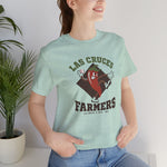 Las Cruces Farmers Premium Lightweight T-Shirt in heather prism mint with the Las Cruces Farmers logo, a red chile pepper pitcher in a high-kick windup on a brown diamond, with Farmers in brown block letters on the front, worn by model