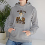 Augusta Tourists Hoodie in sport grey with the cartoon ballplayer with a bat standing on a travel trunk on the front, worn by model