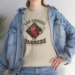 Las Cruces Farmers Heavyweight T-Shirt in sand with the Las Cruces Farmers logo, a red chile pepper pitcher in a high-kick windup on a brown diamond, with Farmers in brown block letters on the front, worn by model