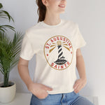 St. Augustine Saints Premium Lightweight T-Shirt in natural with the black and white striped lighthouse emblem with gold rays on the front, worn by model