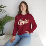 Wenatchee Chiefs Crewneck Sweatshirt in cardinal red with the Wenatchee Chiefs logo, script lettering with an apple stitched like a baseball on the front, worn by model
