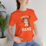 Anniston Rams Premium Lightweight T-Shirt in orange with the Anniston Rams logo, a cartoon ram ballplayer holding a foundry rammer beside a smoking smokestack on the front, worn by model