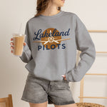Lakeland Pilots Crewneck Sweatshirt in sport grey with the airplane propeller nose art over bold navy block lettering on the front, worn by model