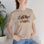 Lakeland Pilots Premium Lightweight T-Shirt in tan with the airplane propeller nose art over bold navy block lettering on the front, worn by model