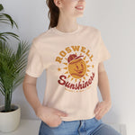 Roswell Sunshiners Premium Lightweight T-Shirt in soft cream with the Roswell Sunshiners logo, a smiling baseball sun in a red cap, with Sunshiners in red script on the front, worn by model