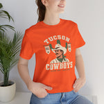 Tucson Cowboys Premium Lightweight T-Shirt in orange with the Tucson Cowboys logo, a cowboy in front of a saguaro with 1941 and 1953 pennant banners on the front, worn by model