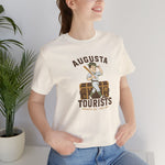 Augusta Tourists Premium Lightweight T-Shirt in natural with the cartoon ballplayer with a bat standing on a travel trunk on the front, worn by model