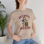 Olympia Senators Premium Lightweight T-Shirt in tan with the Olympia Senators logo, a bearded senator in a frock coat at a podium with a bat on the front, worn by model