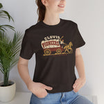 Clovis Pioneers Premium Lightweight T-Shirt in brown with the Clovis Pioneers logo, a ballplayer with a raised bat riding a horse-drawn covered wagon, with Pioneers on the canvas on the front, worn by model