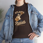Atlanta Pretzels Heavyweight T-Shirt in dark chocolate with the cream cartoon baker holding a pretzel and basket on the front, worn by model