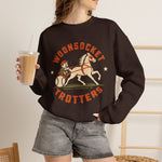 Woonsocket Trotters Crewneck Sweatshirt in dark chocolate with the Woonsocket Trotters logo, a harness racing driver in a baseball cap behind a trotting horse, the sulky wheel drawn as a baseball on the front, worn by model