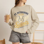 St. Petersburg Saints Crewneck Sweatshirt in sand with the cream winged baseball emblem with a halo on the front, worn by model
