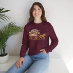 Clovis Pioneers Crewneck Sweatshirt in maroon with the Clovis Pioneers logo, a ballplayer with a raised bat riding a horse-drawn covered wagon, with Pioneers on the canvas on the front, worn by model